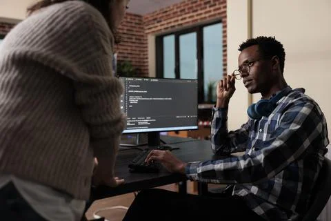 Software developers sitting at desk and developing a functional data encryption Foto stock