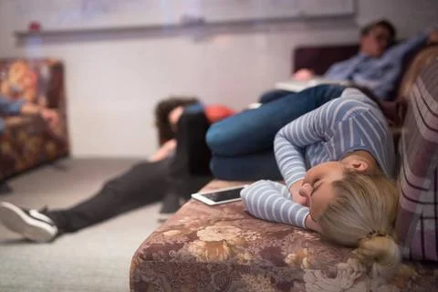 Software developers sleeping on sofa in creative startup office group of y... 스톡 사진