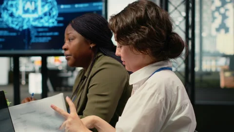 Software developers in startup office brainstorming leveraging AI tech Stock Footage 323030413