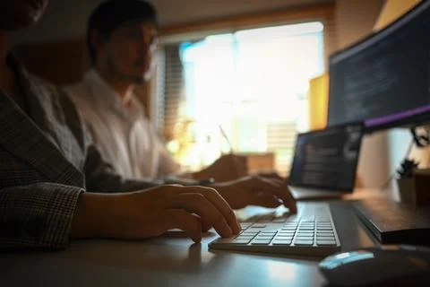 Software developers team programming on desktop computer in share office space Stockfoto's