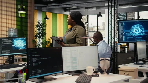 Software developers working in AI startup training predictive models Stock Footage 323144626