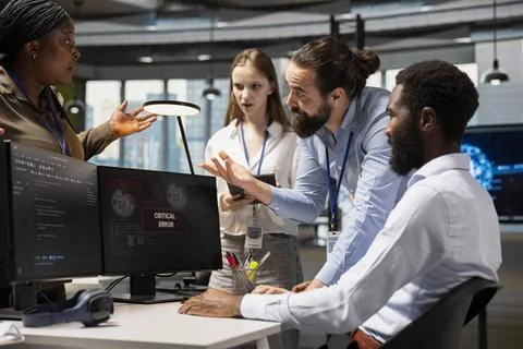 Software developers working together, resolving critical error alert on screen Stock Photos