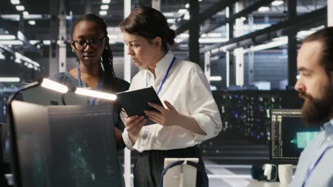 Software developers working together in server farm, reviewing AI code Stock Footage 309614397