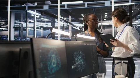 Software developers working together in server farm, reviewing AI code 스톡 사진