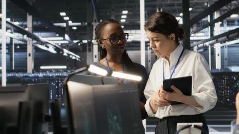 Software developers working together in server farm, reviewing AI code Stockfoto's