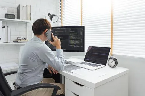 Software development concept, Male programmer talking on smartphone and check 스톡 사진