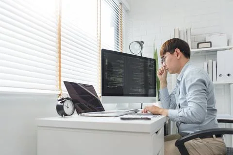 Software development concept, Male programmer looking data on laptop and typi 库存照片