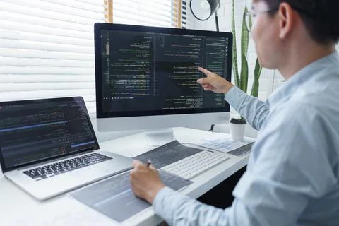 Software development concept, Male programmer checking data codes on document 写真素材