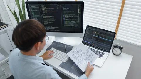 Software development concept, Male programmer read data on document while pro Stockfoto's