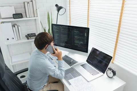 Software development concept, Male programmer talking on smartphone and check Foto stock