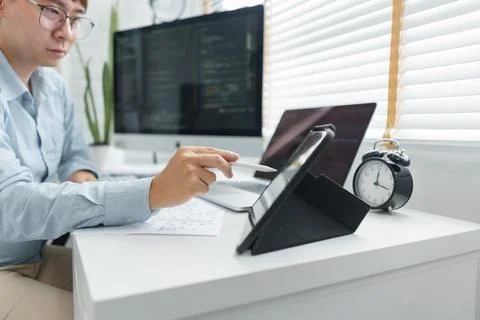 Software development concept, Male programmer point data on tablet to checkin 库存照片