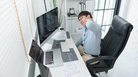 Software development concept, Male programmer suffering neck pain after worki Stockfoto's