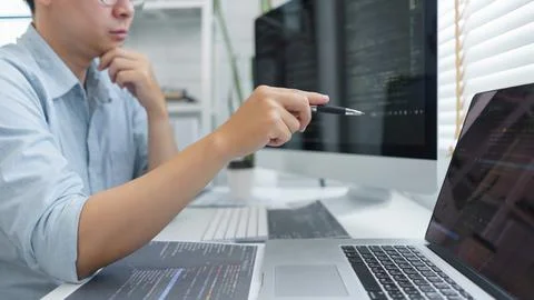 Software development concept, Male programmer pointing on laptop screen to ch 스톡 사진
