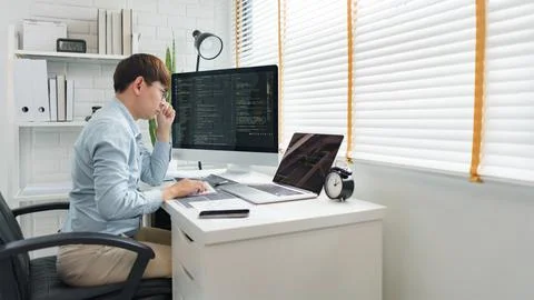 Software development concept, Male programmer looking data on laptop and typi Stockfoto's