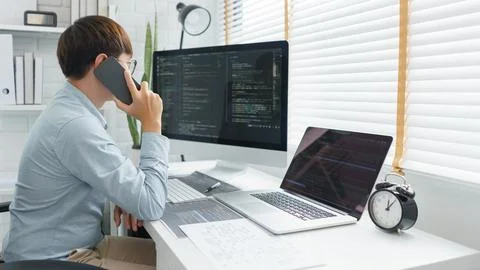 Software development concept, Male programmer talking on smartphone and check 스톡 사진