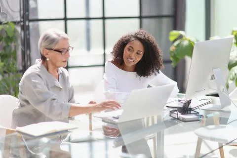 Software development team discussing algorithms on computer screen in office Stock Photos