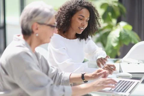 Software development team discussing algorithms on computer screen in office Stock Photos