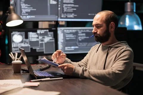 Software engineer analyzing source code with papers 스톡 사진