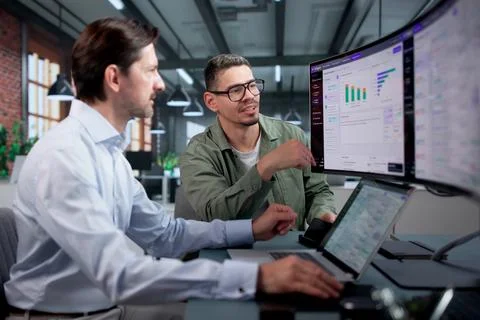 Software Engineer And Colleague Analyze AI Chatbot Responses On Ultrawide Mon Stock Photos