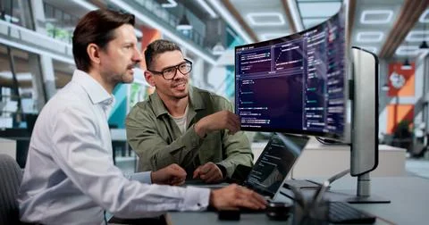 Software Engineer Carefully Codes Secure Platform Using Laptop At Desk. Stock Photos