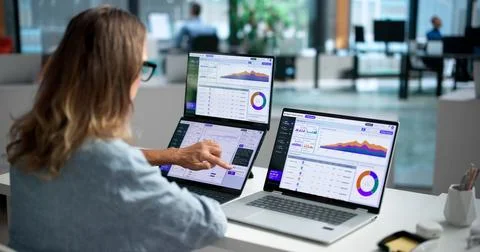 Software Engineer Carefully Monitors AI Platform Performance Using Dual Lapto Stock Photos