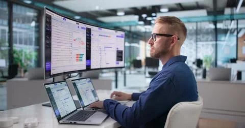 Software Engineer Carefully Monitors AI Orchestration Platform On Ultrawide L 写真素材