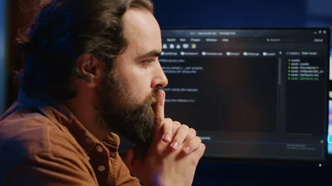 Software engineer concerned, concentrating on finding code bugs, close up Stock Footage 265343483