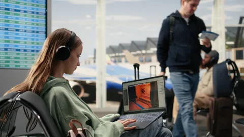 Software engineer creating gaming assets for video game in the airport lounge Stock Footage 333168582