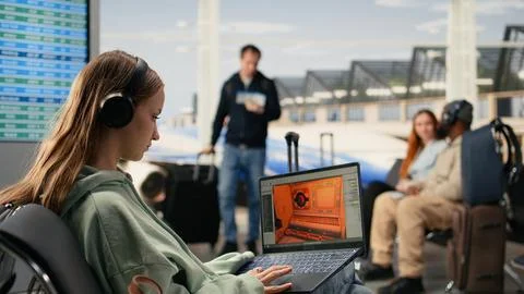 Software engineer creating gaming assets for video game in the airport lounge Stock Photos