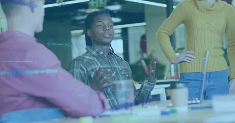 Software engineer gesturing with team at table in tech office, showing floating Stock Footage 308655126