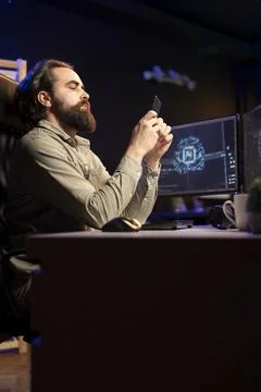Software engineer inserting disk into PC containing AI machine learning data Stock Photos