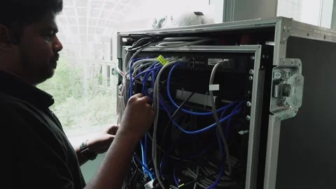 Software engineer organising cables into the back of a server Stock Footage 244787985