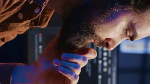 Software engineer puzzled in front of computer screen while writing complex code Stock Footage 265108048