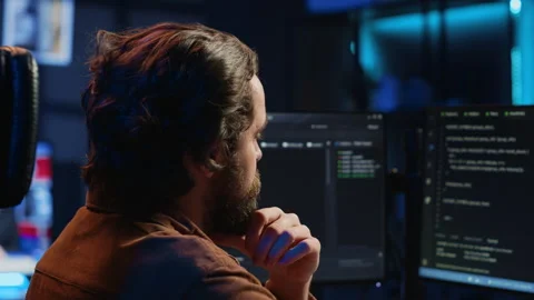 Software engineer puzzled in front of computer screen while writing complex code Stock Footage 265336530