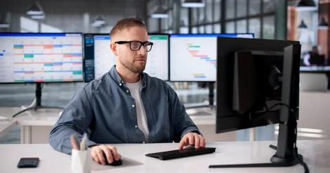 Software Engineer Strategizes Agile Process With Gantt Chart Displayed On Des Stockfoto's