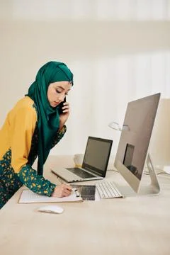 Software engineer taking notes in planner 库存照片
