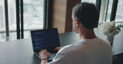 Software engineer at work as he skillfully crafts code on his laptop, providing Stock Footage 271072068