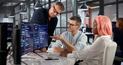 Software Engineer Writes Code Carefully While Collaborating With Colleagues C Stock Photos