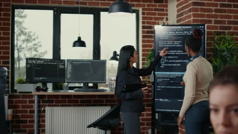 Software engineers analyzing code on wall screen tv looking for bugs and errors Stock Footage 168238257