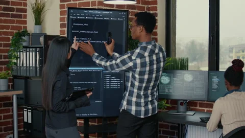 Software engineers analyzing code on wall screen tv comparing errors using Stock Footage 168252417