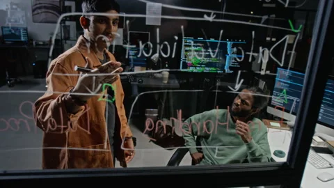 Software Engineers Brainstorming Workflow on Glass Board Stock Footage 348349492
