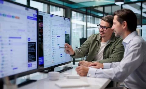 Software Engineers Discuss AI Workflow Dashboards While Tracking Cloud Data C Stock Photos