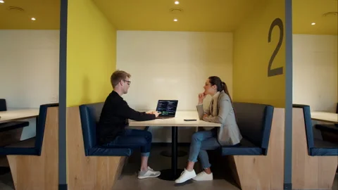 Software engineers discussing a code in a coworking office;Software engineers di Stock Footage 243376739