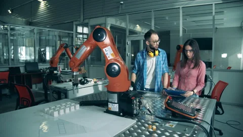 Software experts are observing a functioning robotic arm Video stock 135582253