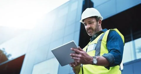 This software help me to keep track of everything. Shot of a engineer using a Stock Photos