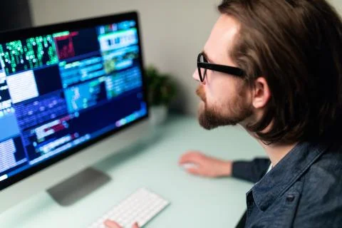 Software man developer on the computer screen and is analyzing the code. Stock Photos