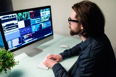 Software man developer on the computer screen and is analyzing the code. Stock Photos