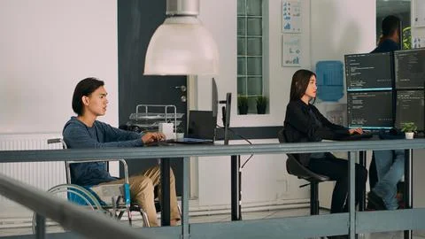 Software programer with physical disability writing code on computer Foto stock