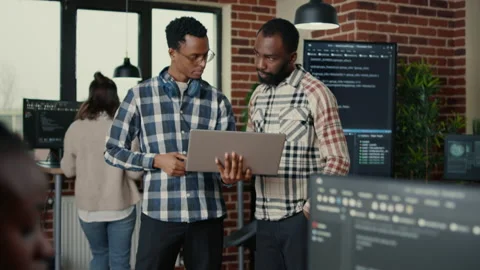 Software programmers talking about algorithms holding laptop switching focus on Stock Footage 168240444