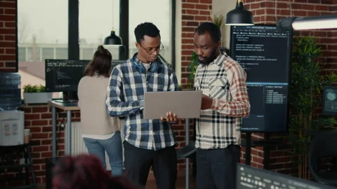 Software programmers talking about algorithms holding laptop and standing in the 動画素材 168242724